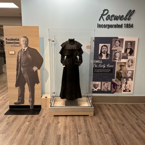 Gallery 1 - Photographs of Theodore Roosevelt, title board for new exhibit, and period dress display